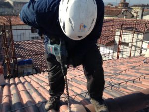 Installazione con ponteggio attorno operatore è in sicurezza non ha funi e imbraghi, indossa il caschetto e si muove agevolmente sulla copertura.